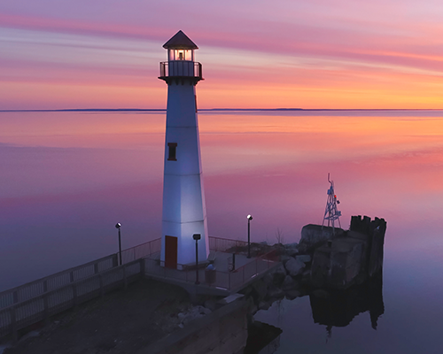 sunset over lake Michigan behind lighthouse